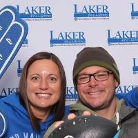 Two alumni posing with gear